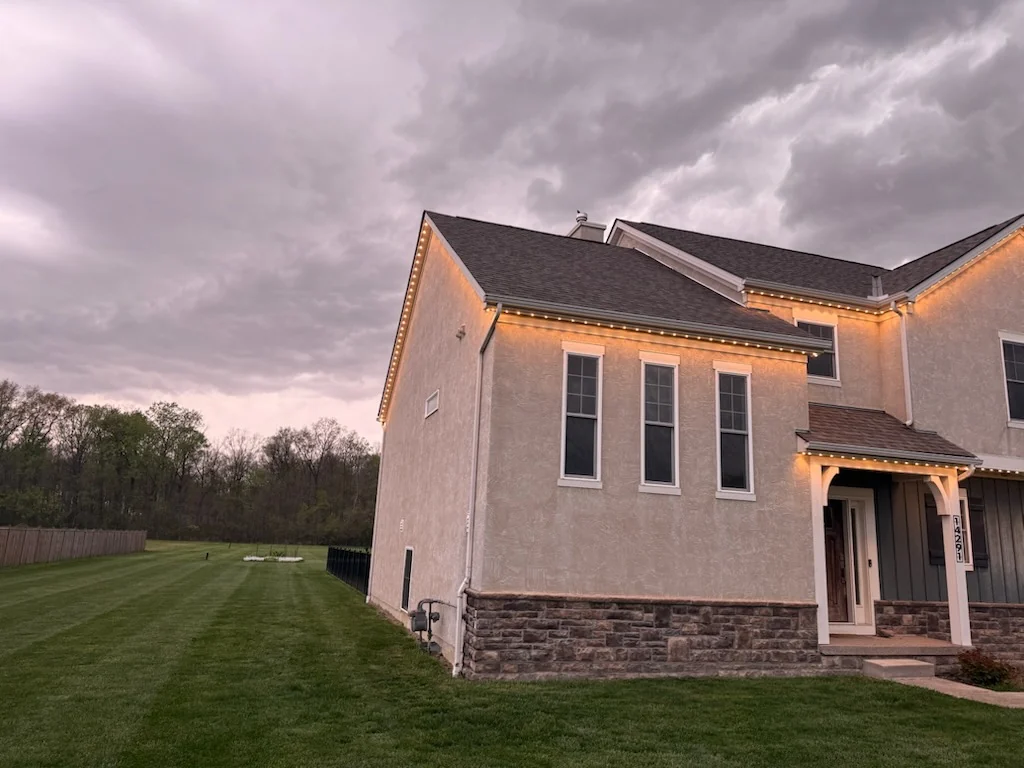 190 ft Dublin OH stucco estate side view showing warm white permanent lights along the back roofline