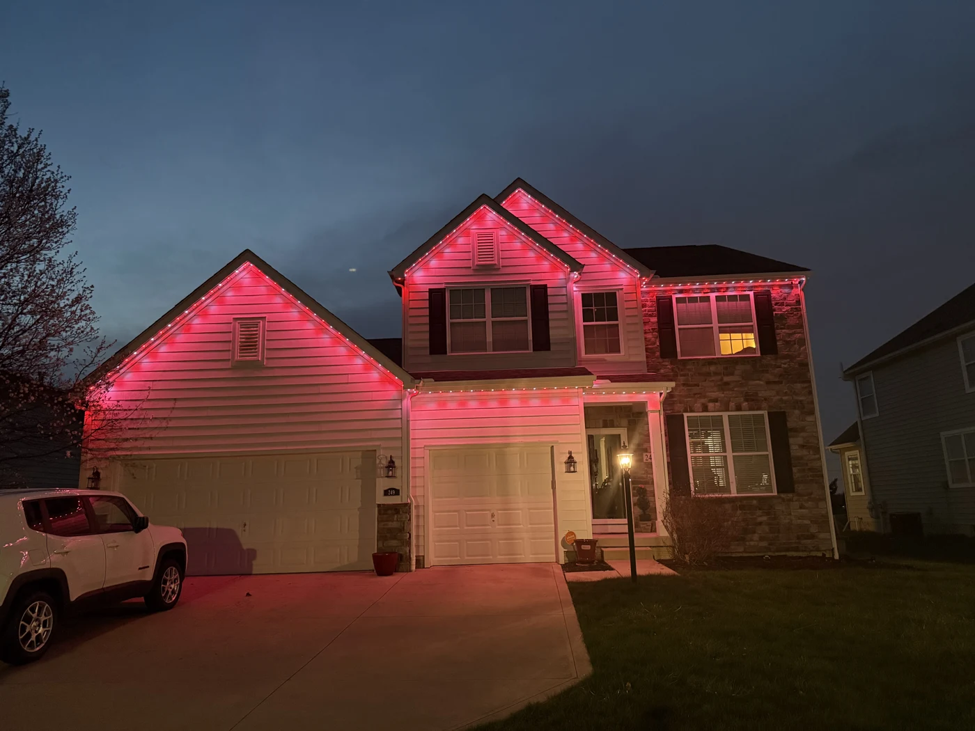 Red and green permanent christmas lights on home at night