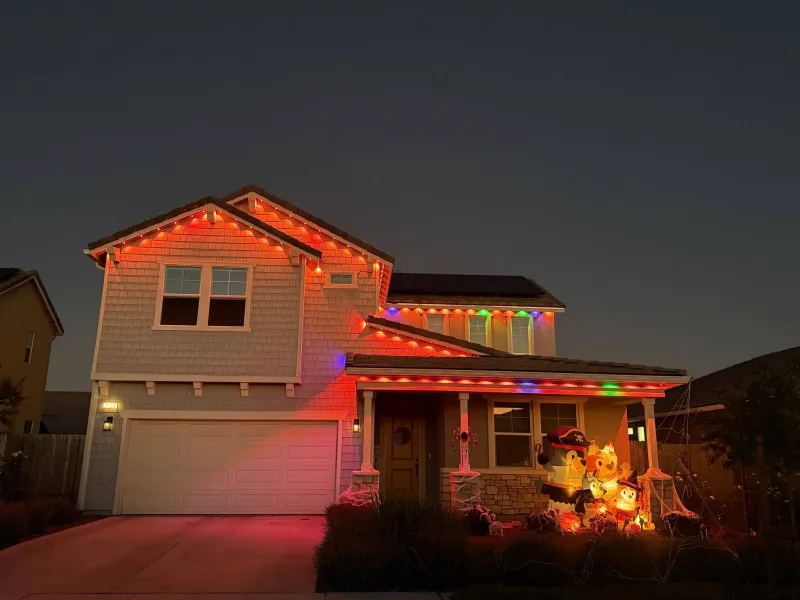 Warm white Govee permanent lights giving a cozy glow along the roofline